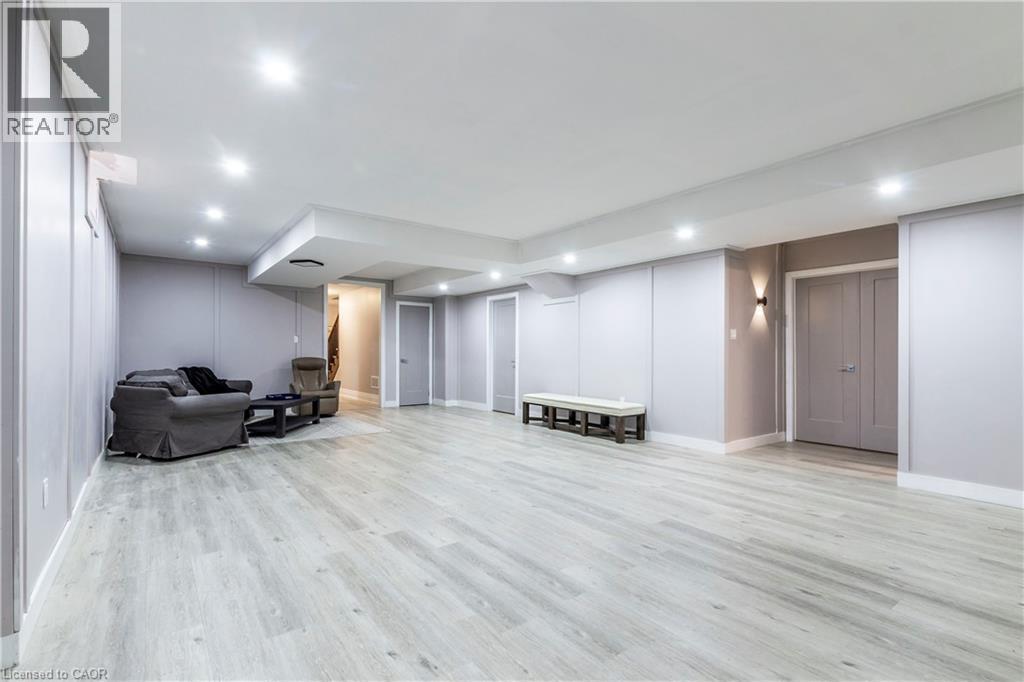 Finished basement with light wood finished floors and recessed lighting - 72 Pond View Gate, Waterdown, ON - Indoor