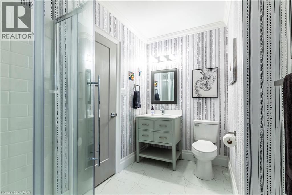 Full bath with crown molding, a stall shower, vanity, wallpapered walls, and light marble finish flooring - 72 Pond View Gate, Waterdown, ON - Indoor Photo Showing Bathroom