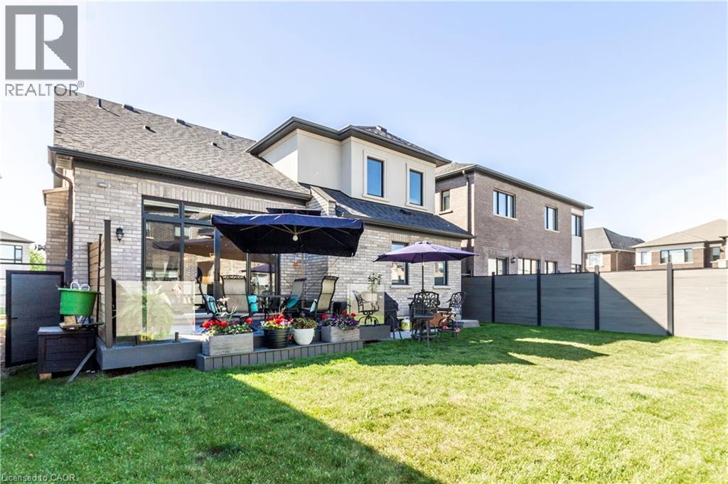 Back of property with brick siding, a fenced backyard, a shingled roof, and a wooden deck - 72 Pond View Gate, Waterdown, ON - Outdoor