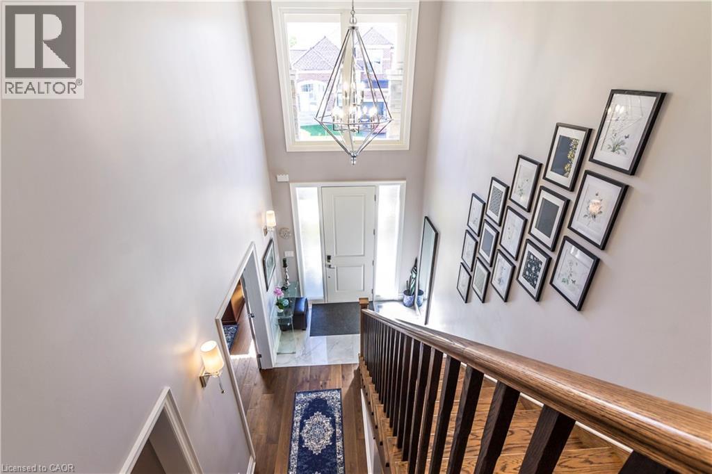 Foyer entrance with a high ceiling, hanging lights, and dark wood finished floors - 72 Pond View Gate, Waterdown, ON - Indoor Photo Showing Other Room