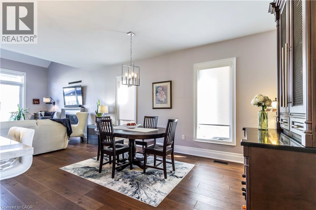 Dining space featuring dark wood-style flooring, suspended lighting, and vaulted ceiling - 72 Pond View Gate, Waterdown, ON - Indoor Photo Showing Dining Room