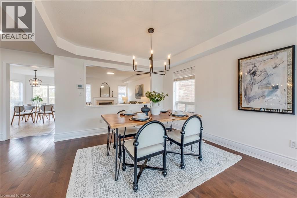 Dining space featuring suspended lighting and dark wood-style flooring - 5811 Page Crescent, Burlington, ON - Indoor Photo Showing Dining Room