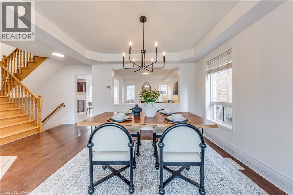 Dining room with a raised ceiling, hanging lights, and dark wood-style flooring - 5811 Page Crescent, Burlington, ON - Indoor