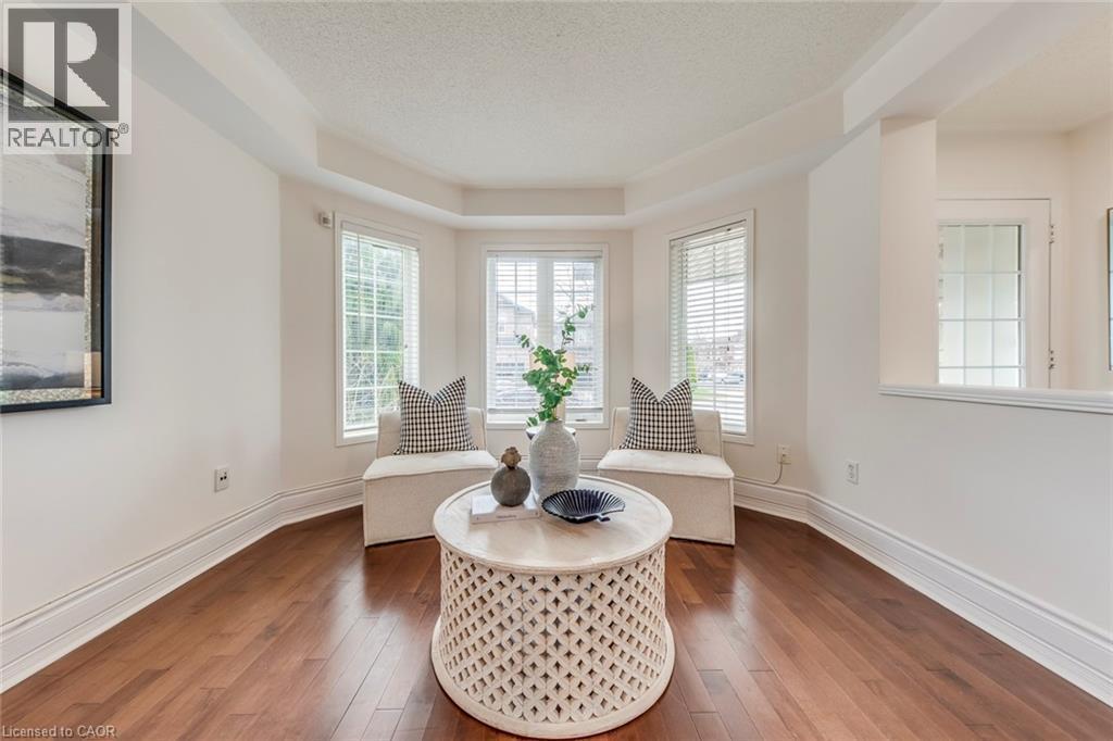 Living area featuring hardwood / wood-style floors, a textured ceiling, plenty of natural light, and a tray ceiling - 5811 Page Crescent, Burlington, ON - Indoor Photo Showing Living Room