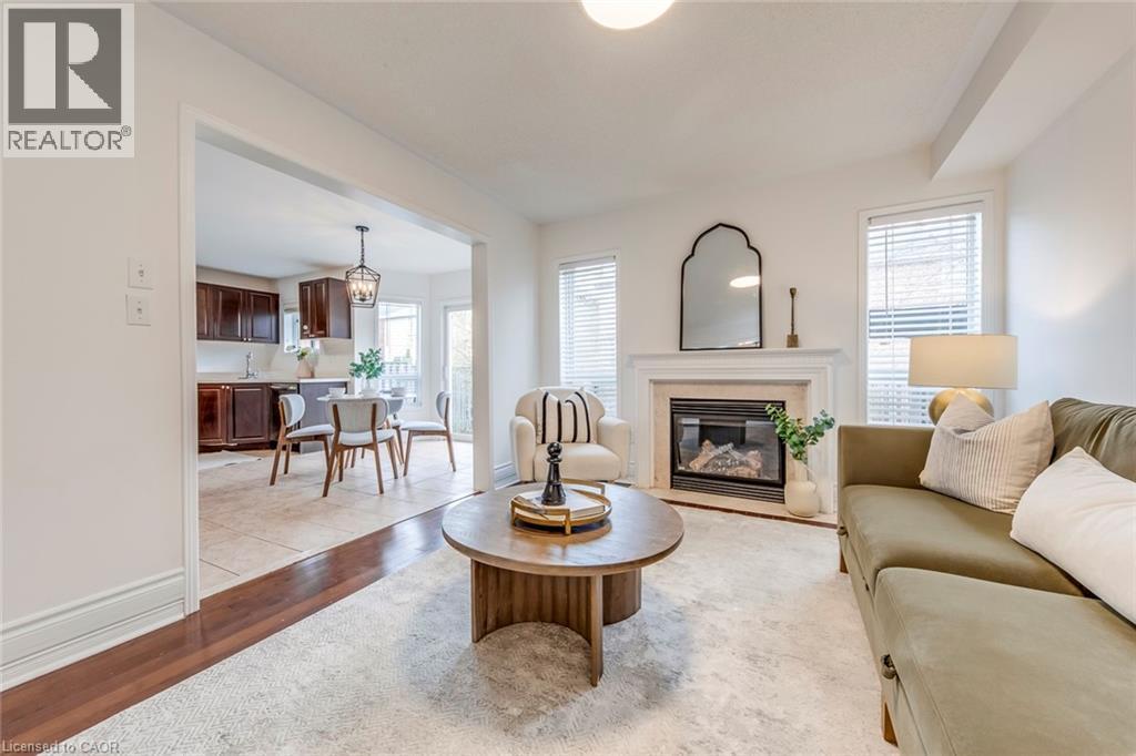 Living area with light wood-style floors, healthy amount of natural light, and a high end fireplace - 5811 Page Crescent, Burlington, ON - Indoor Photo Showing Living Room With Fireplace