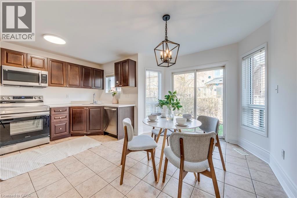 Kitchen featuring stainless steel appliances, light countertops, a chandelier, light tile patterned floors, and healthy amount of natural light - 5811 Page Crescent, Burlington, ON - Indoor Photo Showing Other Room