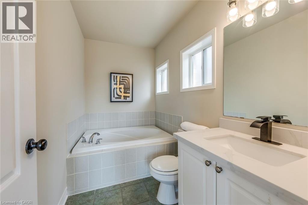Bathroom featuring vanity, a garden tub, and dark tile patterned floors - 5811 Page Crescent, Burlington, ON - Indoor Photo Showing Bathroom