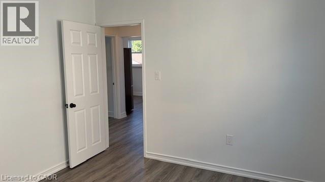 Unfurnished room featuring baseboards and dark wood-type flooring - 322 Upper Gage Avenue, Hamilton, ON - Indoor Photo Showing Other Room