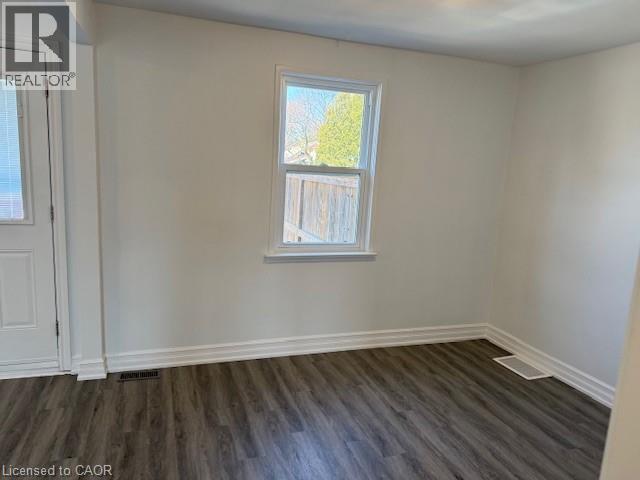 Unfurnished room featuring dark wood-style floors and baseboards - 322 Upper Gage Avenue, Hamilton, ON - Indoor Photo Showing Other Room