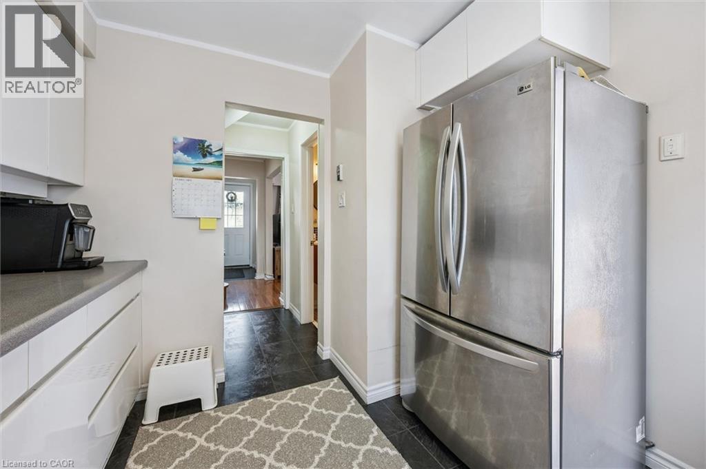 Kitchen with white cabinetry, freestanding refrigerator, crown molding, and light countertops - 55 Ralgreen Crescent, Kitchener, ON - Indoor Photo Showing Kitchen