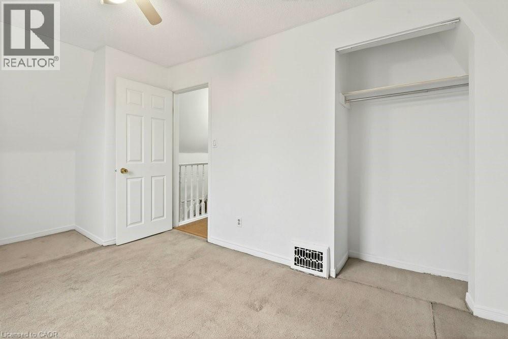 Unfurnished bedroom featuring light carpet and a ceiling fan - 23 Frederick Avenue, Hamilton, ON - Indoor Photo Showing Other Room