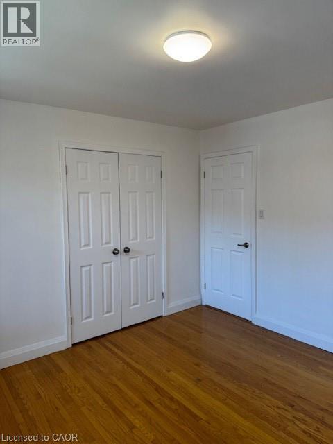 Unfurnished bedroom with dark wood-style flooring and a closet - 31 Adair Avenue, Hamilton, ON - Indoor Photo Showing Other Room