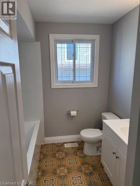 Full bath with vanity, a bath, and dark tile patterned flooring - 31 Adair Avenue, Hamilton, ON - Indoor Photo Showing Bathroom
