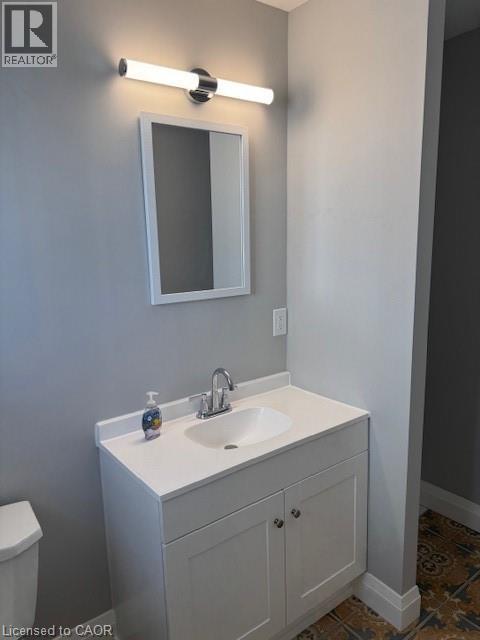 Bathroom with vanity and dark tile patterned floors - 31 Adair Avenue, Hamilton, ON - Indoor Photo Showing Bathroom