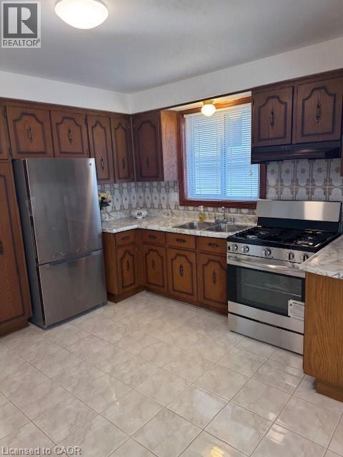 Kitchen with stainless steel appliances, light countertops, and dark wood finish cabinetry - 31 Adair Avenue, Hamilton, ON - Indoor Photo Showing Kitchen With Double Sink