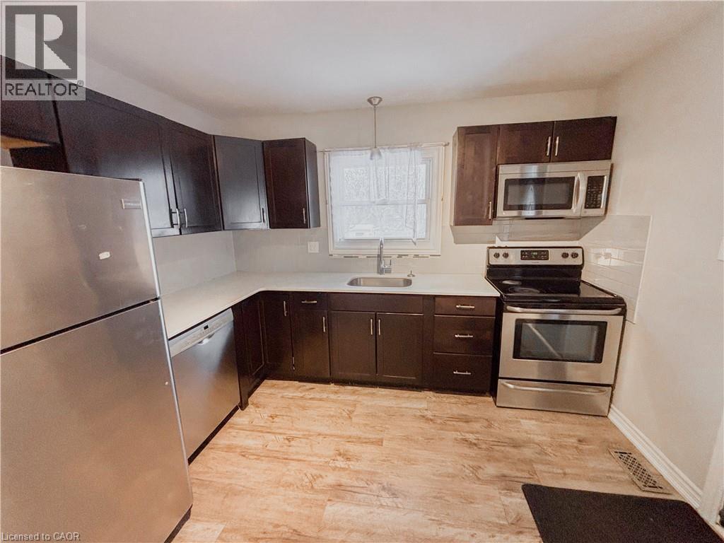 Kitchen featuring stainless steel appliances, dark wood finish cabinetry, and light countertops - 122 Weber Street S, Waterloo, ON - Indoor Photo Showing Kitchen