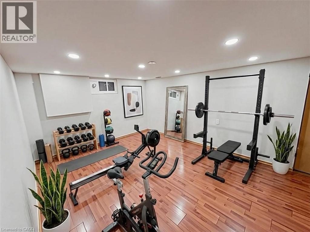 Exercise area with light wood-style floors and recessed lighting. Basement. Virtually staged. - 122 Weber Street S, Waterloo, ON - Indoor