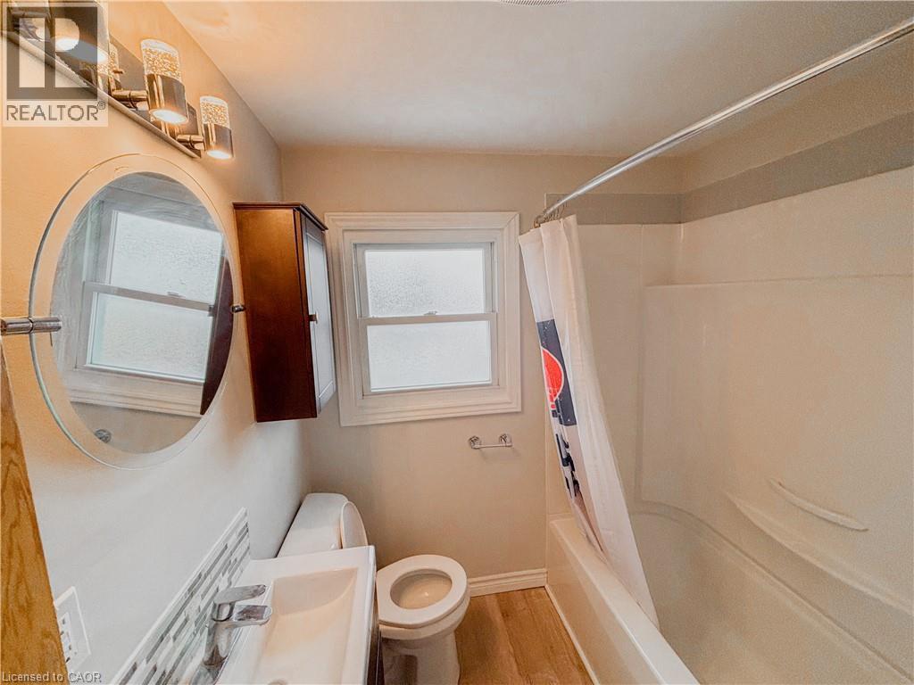 Full bathroom featuring shower / tub combo with curtain, light wood finished floors, and vanity - 122 Weber Street S, Waterloo, ON - Indoor