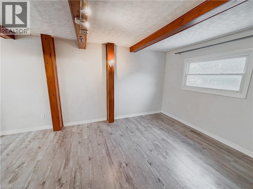 Basement with light wood-style flooring and a textured ceiling - 122 Weber Street S, Waterloo, ON - Indoor Photo Showing Other Room
