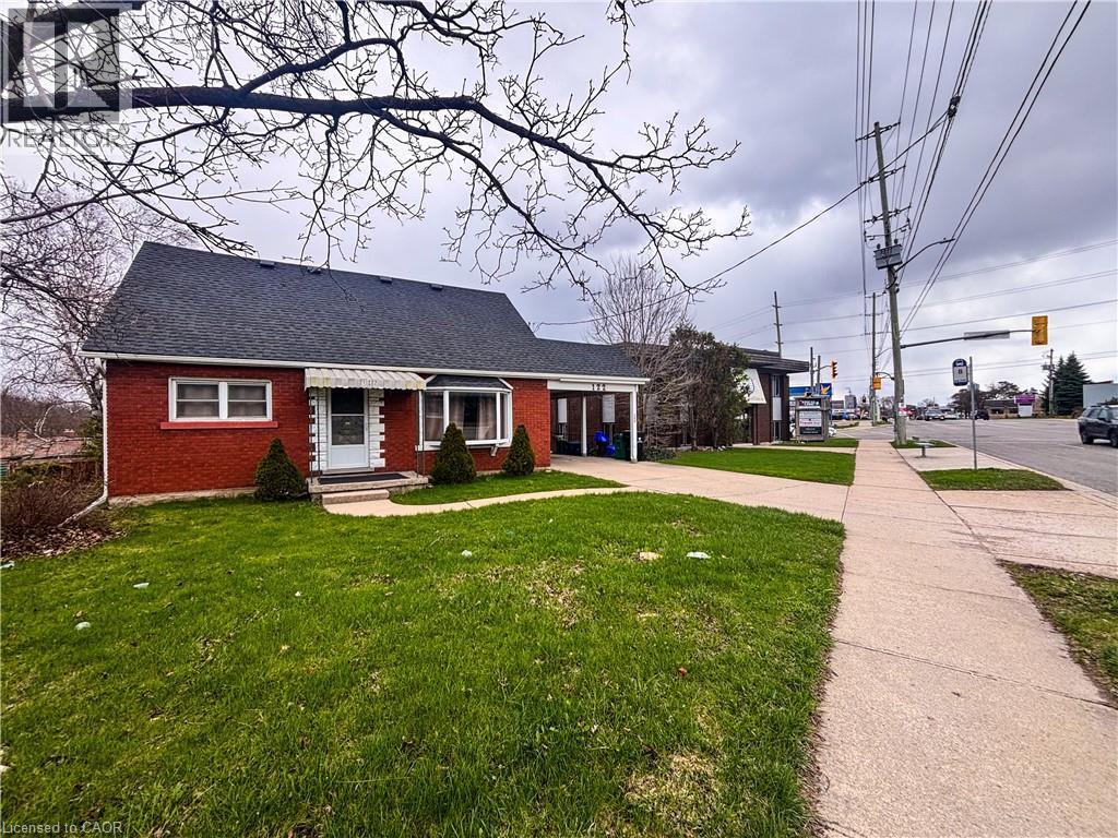 The property features a red brick exterior, a dark shingled roof, and a green lawn - 122 Weber Street S, Waterloo, ON - Outdoor
