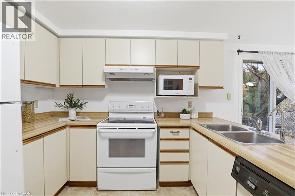 Kitchen featuring white appliances and light countertops - 56 Rushbrook Drive, Kitchener, ON - Indoor Photo Showing Kitchen With Double Sink