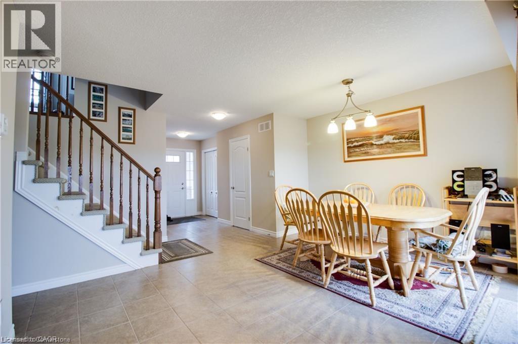 Tiled dining room featuring a textured ceiling and an inviting chandelier - 101 Robert Simone Way, Ayr, ON - Indoor Photo Showing Dining Room