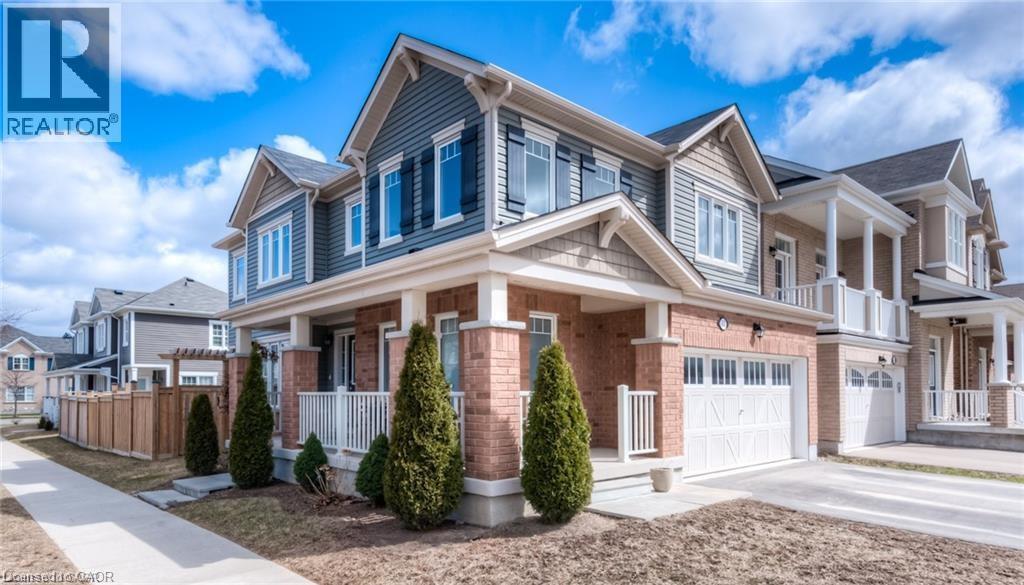 View of side of property with a garage, driveway, a porch, brick siding, and a residential view - 60 Postmaster Drive, Kitchener, ON - Outdoor With Facade