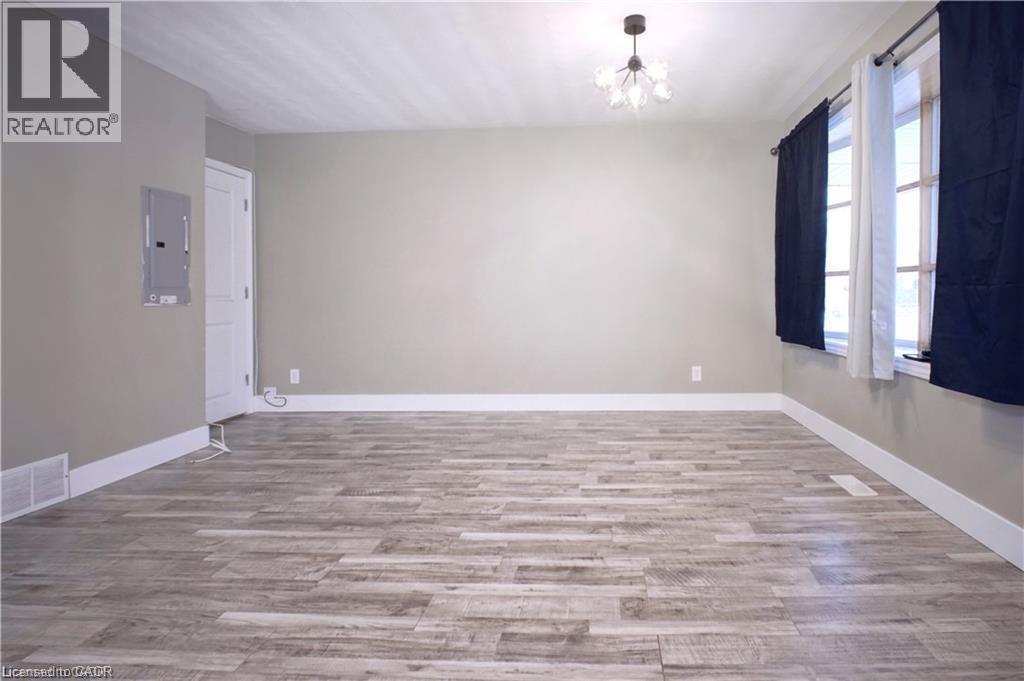 Unfurnished room featuring suspended lighting, light wood-style floors, and electric panel - 61 Bosworth Crescent Unit# Upper, Kitchener, ON - Indoor Photo Showing Other Room