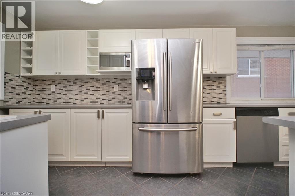 Kitchen with stainless steel appliances, white cabinets, dark tile patterned floors, and open shelves - 61 Bosworth Crescent Unit# Upper, Kitchener, ON - Indoor Photo Showing Kitchen With Stainless Steel Kitchen