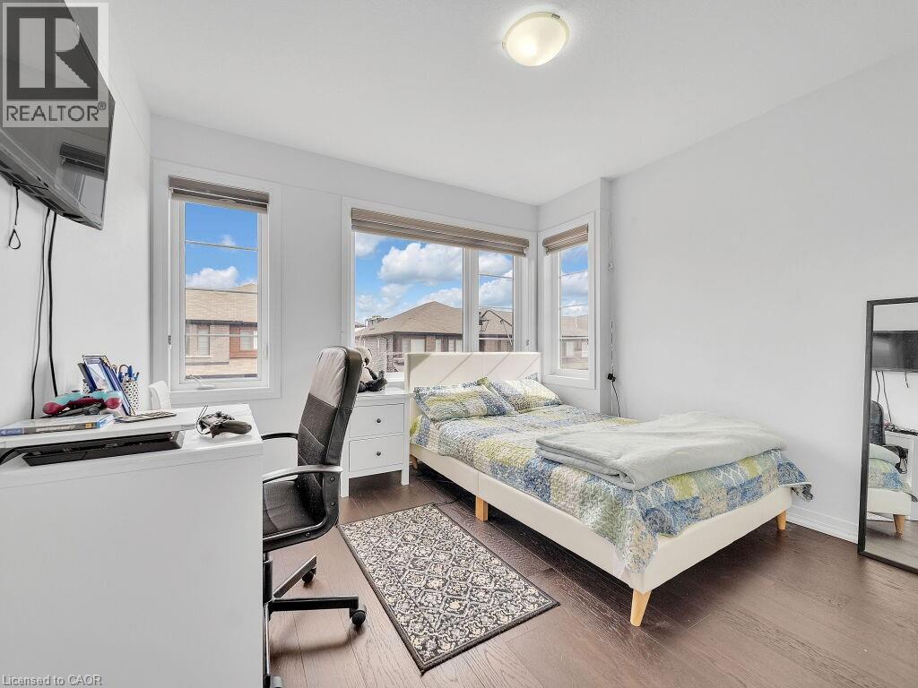 Bedroom featuring a desk, dark wood-type flooring, and multiple windows - 30 Times Square Boulevard, Hamilton, ON - Indoor Photo Showing Bedroom