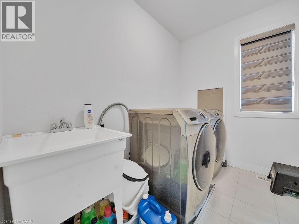 Laundry area featuring light tile patterned floors and washing machine and clothes dryer - 30 Times Square Boulevard, Hamilton, ON - Indoor Photo Showing Laundry Room