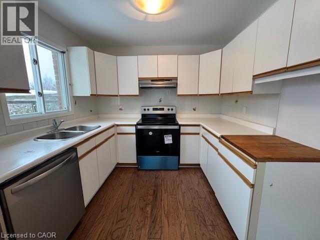 Kitchen featuring stainless steel appliances, dark wood-type flooring, light countertops, backsplash, and dual tone cabinets - 536 Thorndale Drive, Waterloo, ON - Indoor Photo Showing Kitchen With Double Sink