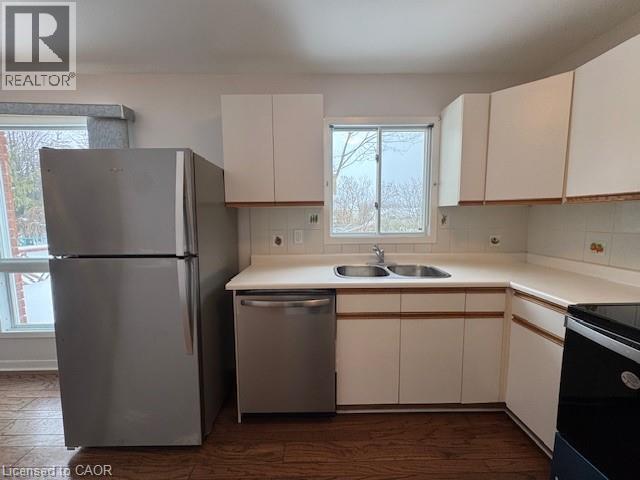 Kitchen featuring stainless steel appliances, tasteful backsplash, light countertops, and dark wood finished floors - 536 Thorndale Drive, Waterloo, ON - Indoor Photo Showing Kitchen With Double Sink