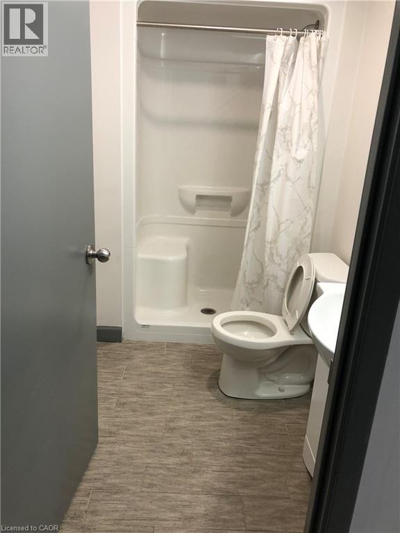 Full bath featuring a shower stall, vanity, and dark wood finished floors - 258 Sunview Street Unit# 225, Waterloo, ON - Indoor Photo Showing Bathroom