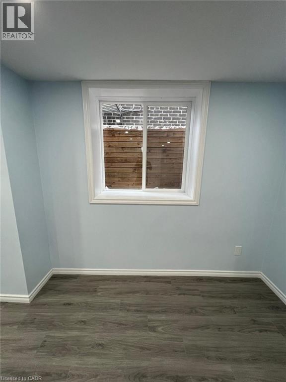 Unfurnished room with baseboards and dark wood-style floors - 167 Histand Trail Unit# Lower, Kitchener, ON - Indoor Photo Showing Other Room