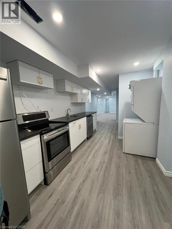 Kitchen featuring stainless steel appliances, white cabinetry, dark countertops, light wood-style flooring, and recessed lighting - 167 Histand Trail Unit# Lower, Kitchener, ON - Indoor Photo Showing Kitchen