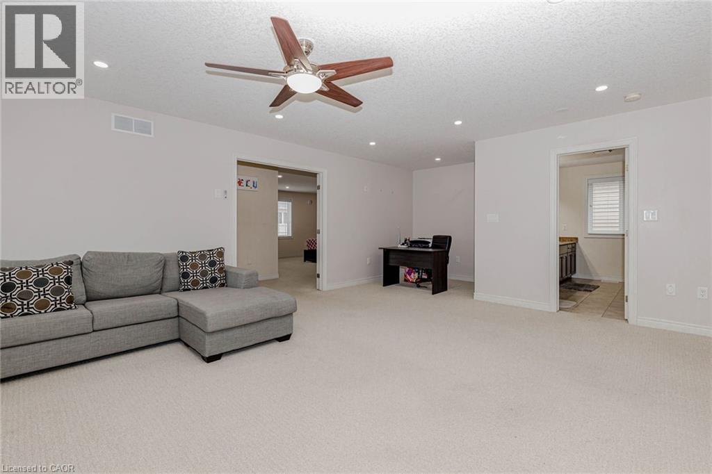 Living area featuring light carpet, a textured ceiling, a ceiling fan, recessed lighting, and plenty of natural light - 2 Doon Creek Street, Kitchener, ON - Indoor Photo Showing Other Room