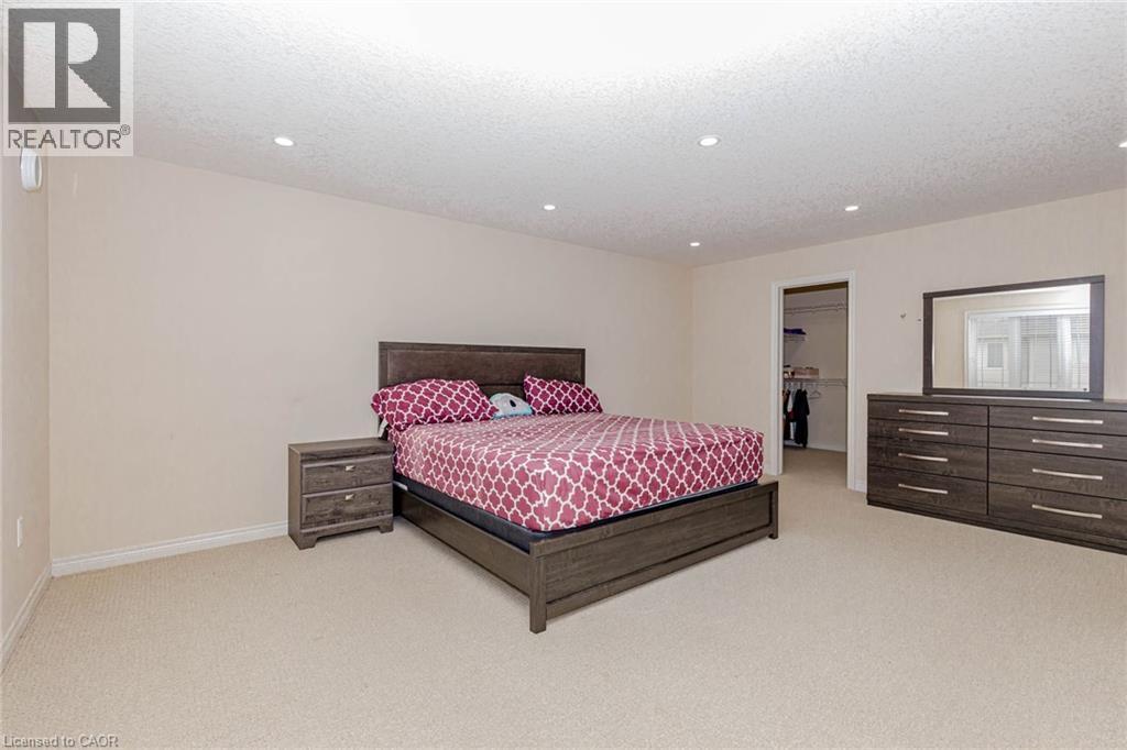 Bedroom featuring a spacious closet, light carpet, recessed lighting, and a textured ceiling - 2 Doon Creek Street, Kitchener, ON - Indoor Photo Showing Bedroom