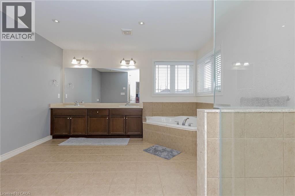 Bathroom featuring double vanity, a bath, a stall shower, and light tile patterned floors - 2 Doon Creek Street, Kitchener, ON - Indoor Photo Showing Bathroom