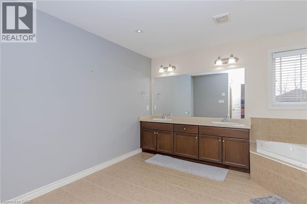Full bathroom with double vanity, a bath, and light tile patterned floors - 2 Doon Creek Street, Kitchener, ON - Indoor Photo Showing Bathroom