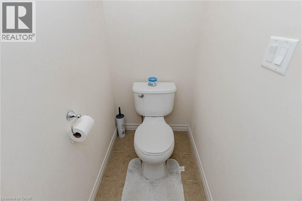 Bathroom featuring toilet and light tile patterned floors - 2 Doon Creek Street, Kitchener, ON - Indoor Photo Showing Bathroom