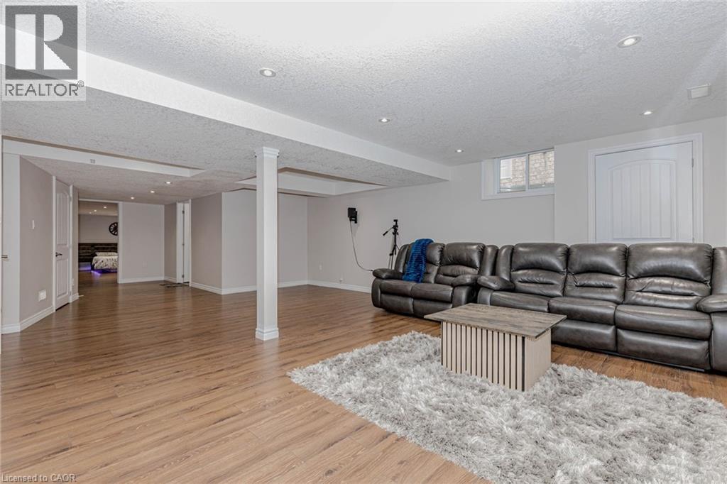 Living area featuring light wood-style floors, a textured ceiling, and recessed lighting - 2 Doon Creek Street, Kitchener, ON - Indoor Photo Showing Living Room