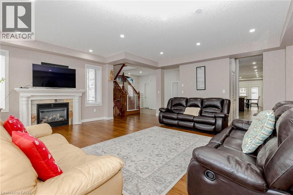 Living room with light wood finished floors and a high end fireplace - 2 Doon Creek Street, Kitchener, ON - Indoor Photo Showing Living Room With Fireplace