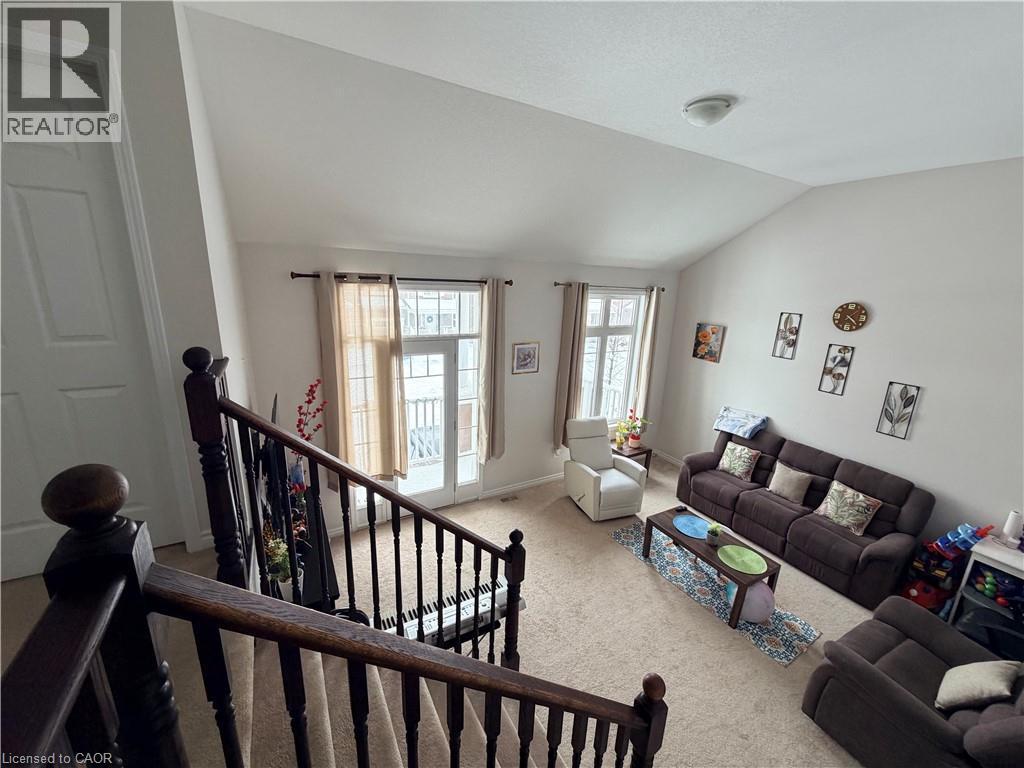 Living room featuring light colored carpet and lofted ceiling - 31 Sofitel Drive, Kitchener, ON - Indoor