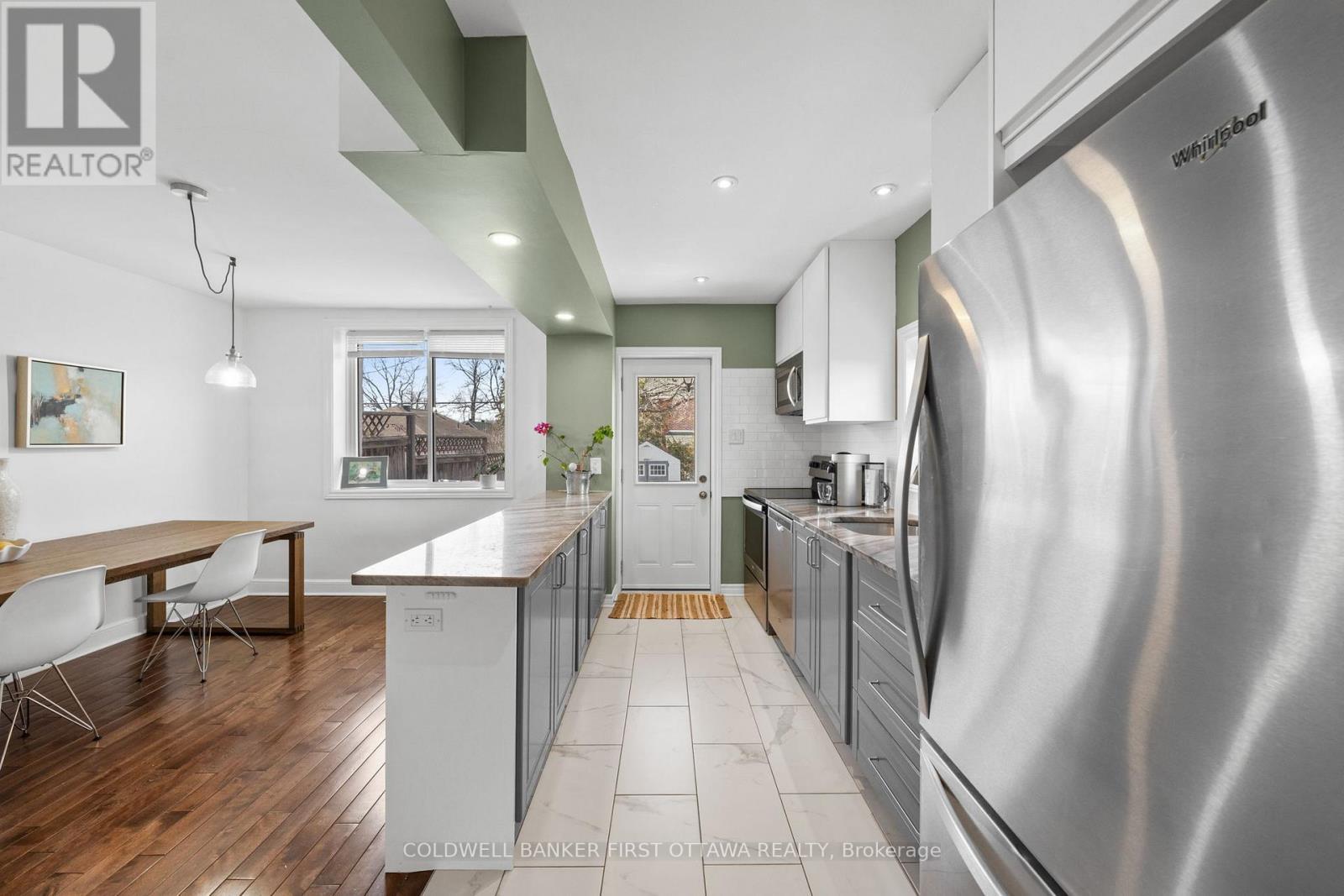 Ceramic tiled floor & walkout to the back deck. - 12 Stevenson Avenue, Ottawa, ON - Indoor Photo Showing Kitchen With Double Sink