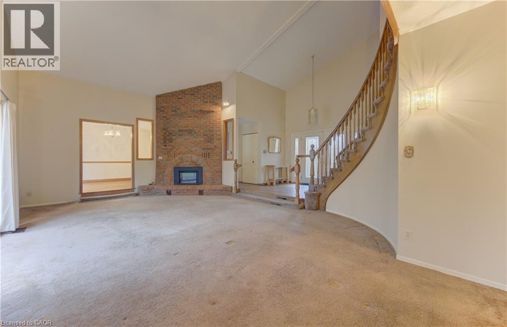 Unfurnished living room featuring vaulted ceiling, carpet, and a fireplace - 190 Silvercrest Drive, Waterloo, ON - Indoor Photo Showing Other Room With Fireplace