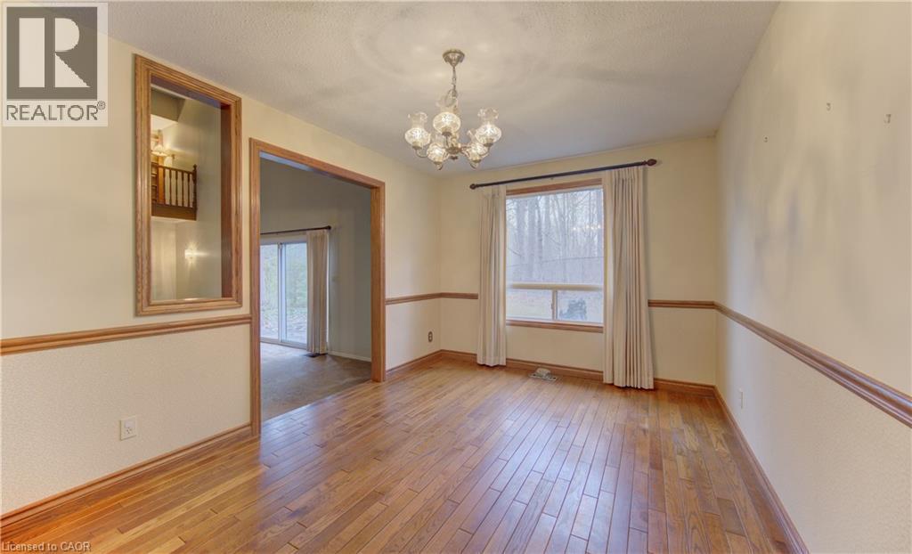 Spare room featuring a chandelier, light wood-type flooring, and a textured ceiling - 190 Silvercrest Drive, Waterloo, ON - Indoor Photo Showing Other Room