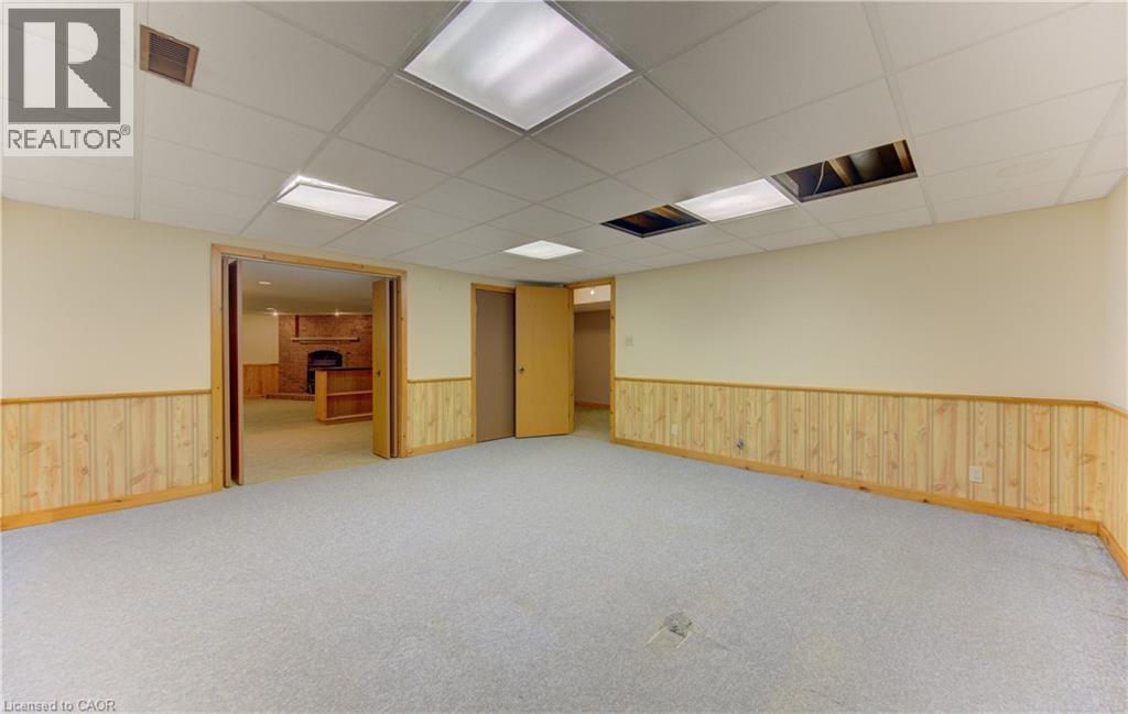 Spare room with a paneled ceiling, light colored carpet, and a brick fireplace - 190 Silvercrest Drive, Waterloo, ON - Indoor Photo Showing Other Room