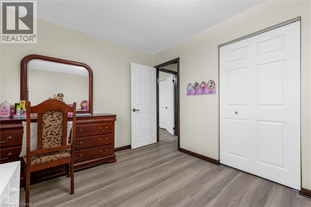 Bedroom featuring dark wood-style floors, a closet, and a textured ceiling - 51 Independence Drive, Hamilton, ON - Indoor