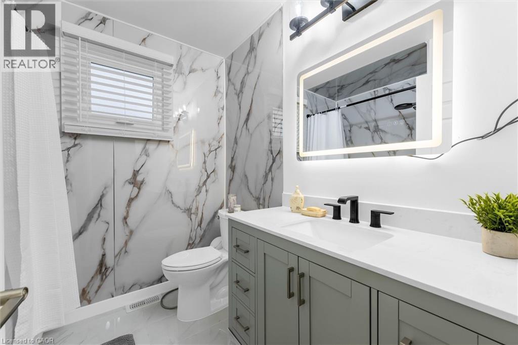 Full bath with a marble finish shower, vanity, stone wall, and light marble finish flooring - 51 Independence Drive, Hamilton, ON - Indoor Photo Showing Bathroom